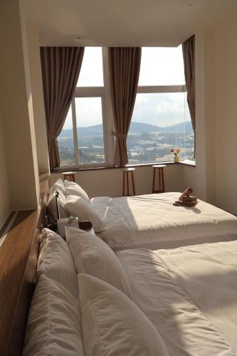 a bedroom with two beds in front of a window at 1909 Home Dalat - Open 24h in Ấp Kim Thạch