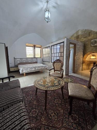 a living room with a couch and a table and chairs at Al qasr in Mashabbe Sade