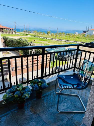 a blue chair sitting on a balcony with plants at Seaside Christina Apartments in Ierissos