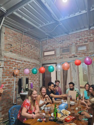a group of people sitting at a table with balloons at Jomariz Homestay in Labuan Bajo