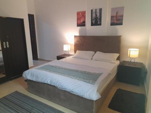 a bedroom with a large bed with two lamps at Double room in Villa Narges New Cairo in Cairo