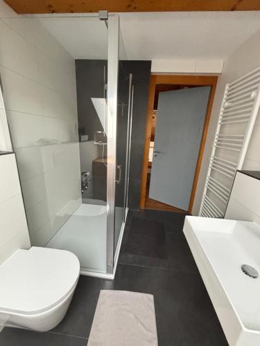 ein weißes Badezimmer mit Toilette und Waschbecken in der Unterkunft Ferienwohnung Schillerstaße in Haiger