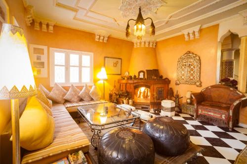 a living room with a couch and a fireplace at Riad Dar Sofian in Zagora
