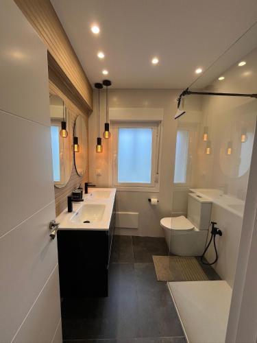 a bathroom with two sinks and a toilet and a window at Balcón del cubo in Covaleda