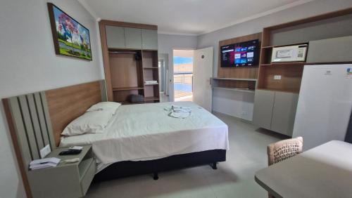 a hotel room with a bed and a television at Araras Apart Service in Caldas Novas