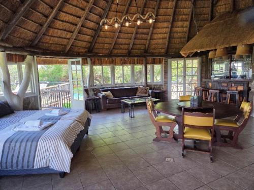 a bedroom with a bed and a table in a room at Vaalkrans Game Lodge in Heilbron