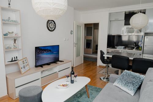 a living room with a couch and a tv at SK Blue apartment in Lukavica
