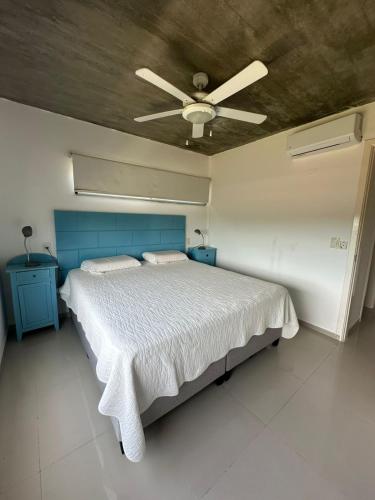 a bedroom with a bed with a ceiling fan at Arenas Garzón in José Ignacio