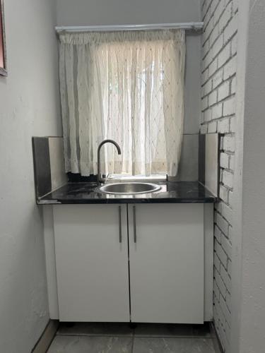 a sink in a room with a window at The Wentworth Guest House in Krugersdorp