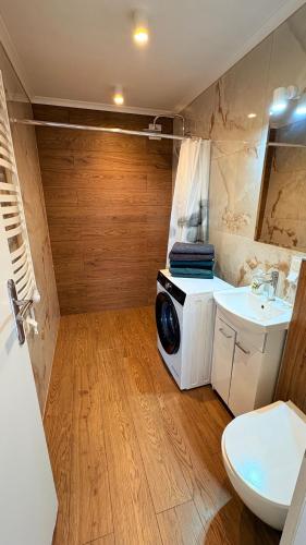 a bathroom with a washing machine and a sink at Domki Premium Nad Bałtykiem in Wodnica