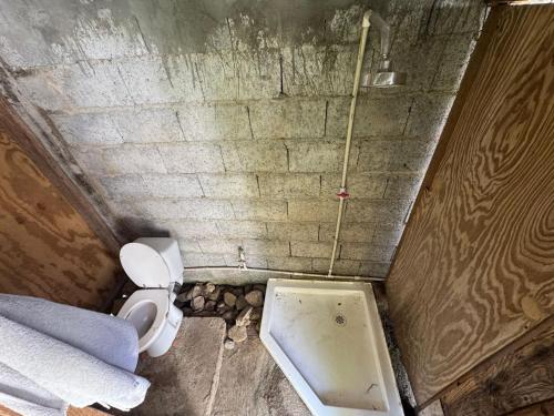 brudna łazienka z toaletą i wanną w obiekcie Rasta Rustic Off Grid Cabin w mieście Gros Islet