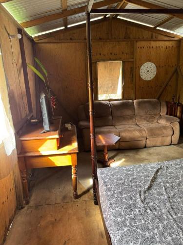 salon z kanapą i stołem w obiekcie Rasta Rustic Off Grid Cabin w mieście Gros Islet