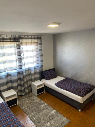 a bedroom with two beds and two tables in it at Apartman Ninkovic in Pale