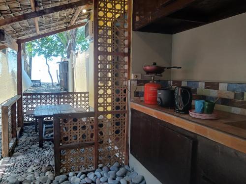 a kitchen with a counter with a stove and a window at Sunset View Guest House in Camiguin