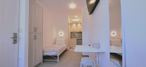 a small white room with a table and a bench at Volca Studios ΙΙ in Emporio
