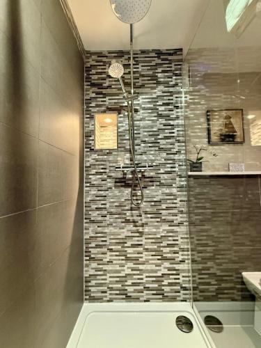 a bathroom with a shower with a tile wall at Modern 3 Bedroom Apartment, West End in Edinburgh