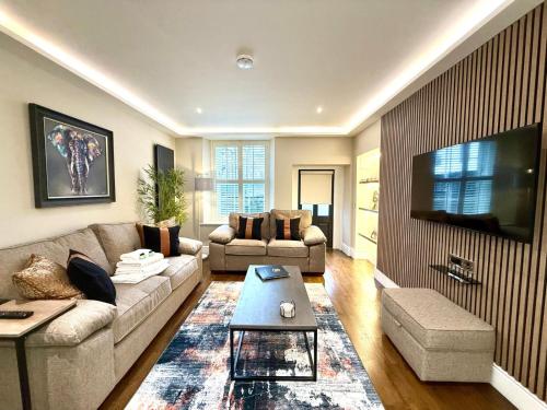 a living room with a couch and a tv at Modern 3 Bedroom Apartment, West End in Edinburgh