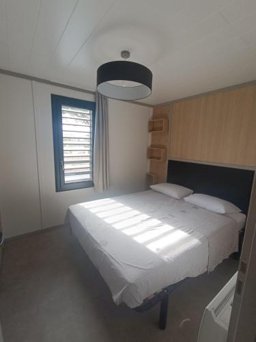 a bedroom with a large white bed with a window at Cottage haut de gamme, tout confort in Agde