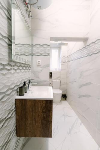 a white bathroom with a sink and a toilet at NDK - UrbanLux Medius 2BDR FREE Parking in Sofia