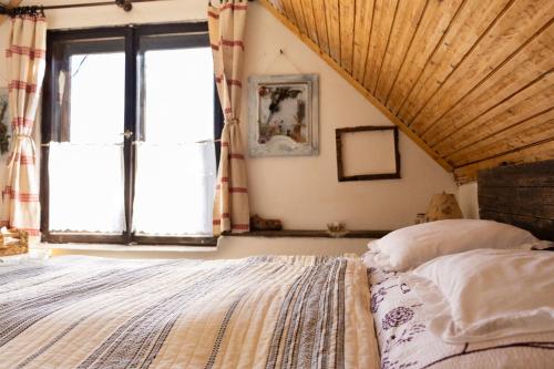 a bedroom with a large bed and a window at Menyecske Guesthouse in Keszü