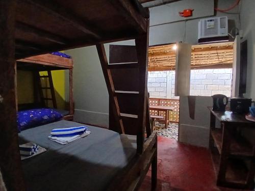 a room with two bunk beds and a kitchen at Sunset View Guest House in Camiguin
