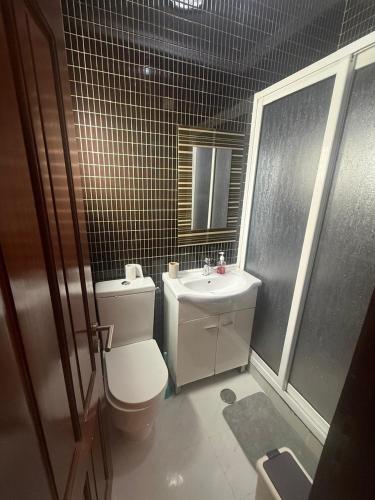 a bathroom with a toilet and a sink at House Lima in Lobito