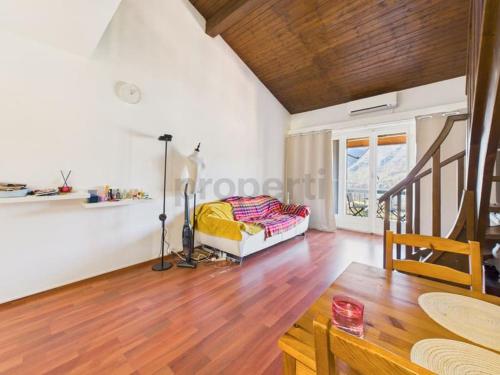 a living room with a bed and a wooden floor at La fornace lago in Melano