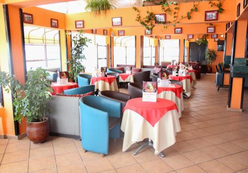 a restaurant with red and blue tables and chairs at New Farah Hotel in Agadir