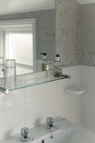 a bathroom with a glass shelf above a sink at The Raincliffe Hotel in Scarborough