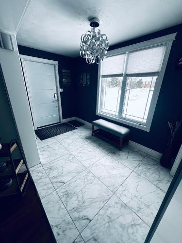 a blue room with a chandelier and a tiled floor at Executive Home in Timmins