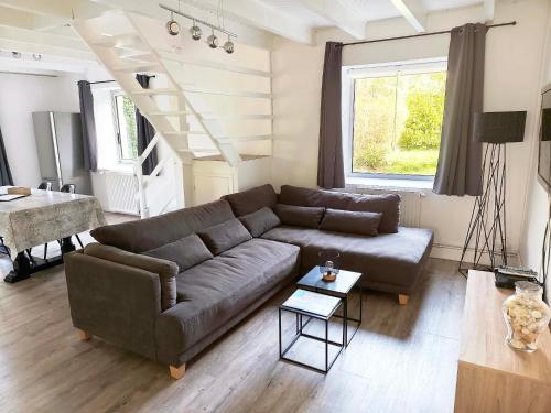 a living room with a couch and a table at Gite Les Sables Blancs in Plobannalec-Lesconil