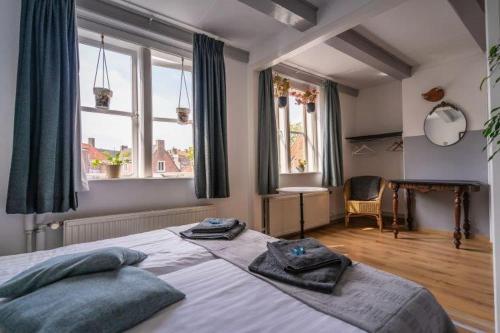 a bedroom with a large bed with towels on it at De Kaepstander in Middelburg