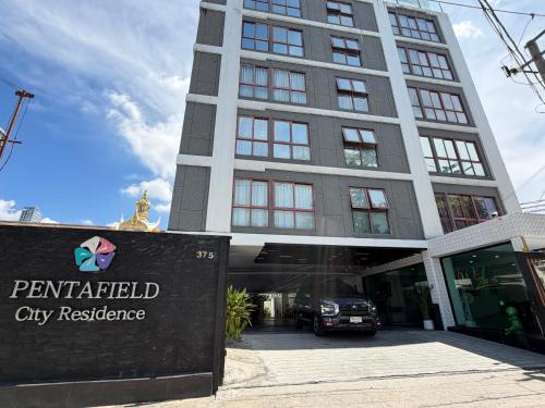 a building with a car parked in front of it at Pentafield City Residence in Amphoe Phra Khanong