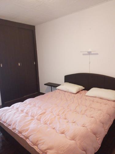 a large bed in a room with a cross on the wall at Dominik in Bar