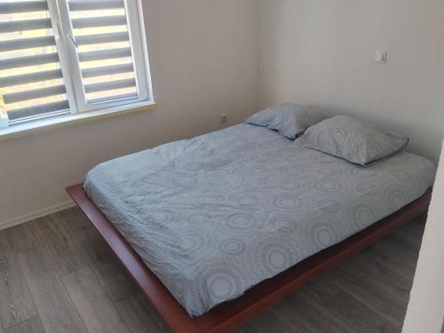 an unmade bed in a bedroom with a window at Apartment D&E in Sarajevo