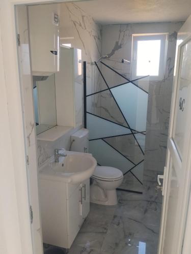 a bathroom with a sink toilet and a mirror at Apartment D&E in Sarajevo