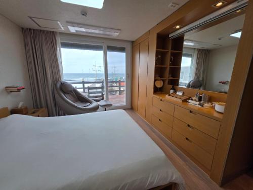 a bedroom with a large bed and a window at Farms Village in Jeju