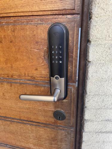 a black remote control on a wooden door at Örkelljunga overnight stay in Orkelljunga