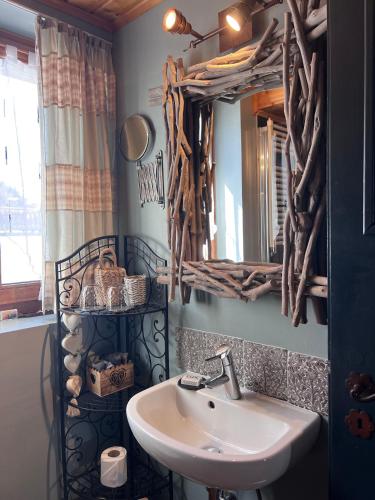 a bathroom with a sink and a mirror at La Demeure des Elfes in Albinen