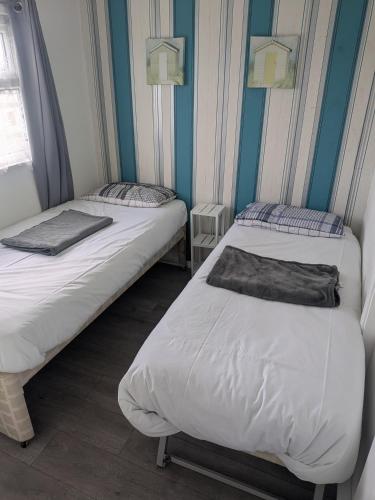 two beds in a room with blue walls at The Bobbers in Great Yarmouth