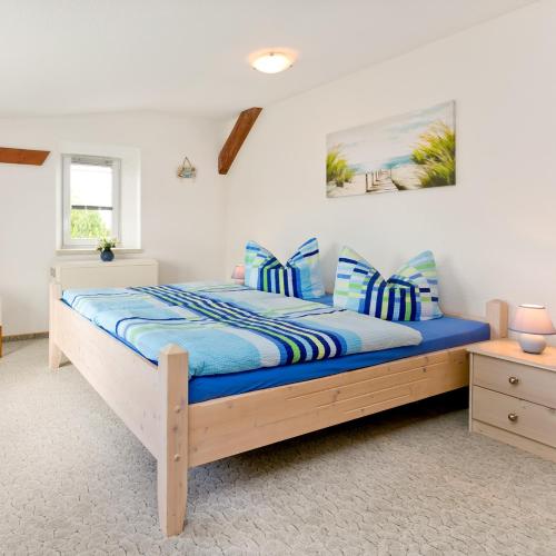 a bedroom with a bed with blue sheets and blue pillows at Ferienwohnung Meeresbrise in Groß Kordshagen