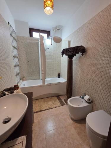 a bathroom with a tub and a toilet and a sink at La Volpe e L'Iris in Campiano, Province of Verona
