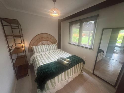 a small bedroom with a bed and a mirror at Dragon Fly in Stormsrivier