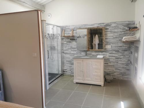 a bathroom with a sink and a glass shower at La petite plaine in Clansayes