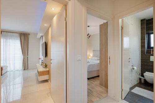 a bathroom with a toilet and a bedroom with a bed at Ralux apartman Tivat in Tivat
