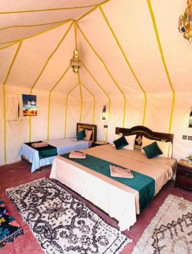 a bedroom with two beds in a tent at Authentic Desert Luxury Camp in Merzouga