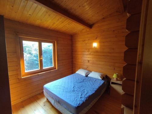 a bedroom with a bed in a log cabin at chalets bois 150m de la plage in Olmeto