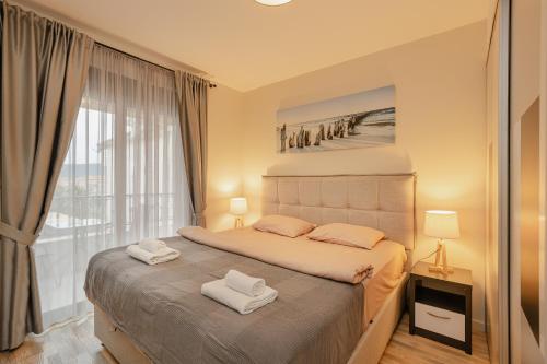 a bedroom with a bed with two towels on it at Ralux apartman Tivat in Tivat