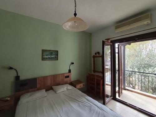 a bedroom with a bed and a large window at Kalama Apartments in Kalamos