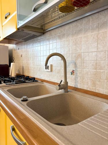 a kitchen sink with a faucet next to a stove at Aura LT - Vicinissima all'aeroporto in Fiumicino